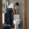 fontanero arreglando un sanitario en una casa